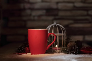 closeup.red Christmas Cup and the candle on the holiday table