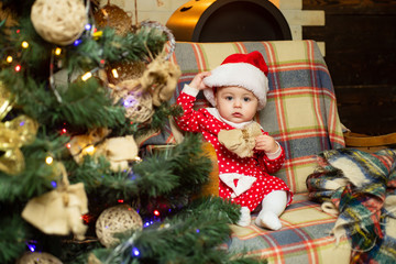 Child with a Christmas present on wooden background. Happy children. Christmas Babies. Cute little child is decorating Christmas tree indoors.