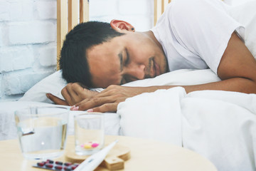 Fototapeta na wymiar Asian man sick and sleep on bed in bedroom