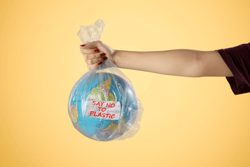 Unknown woman holds plastic bag and earth globe