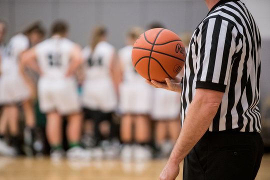 Referee holding basketball during timeout