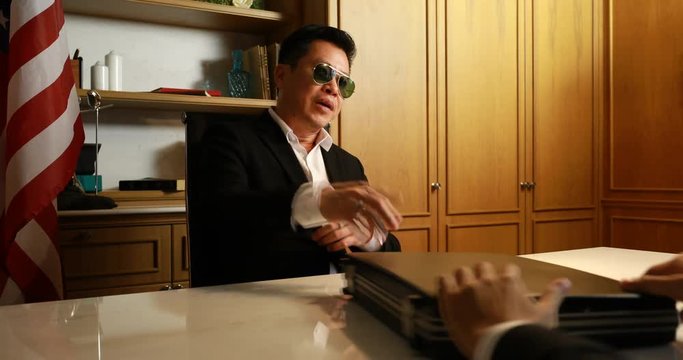Business owner (Boss) giving dollars money bag. Dark business concept.