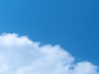 Obraz premium A background of the deep blue sky half covered with a patch of cloud