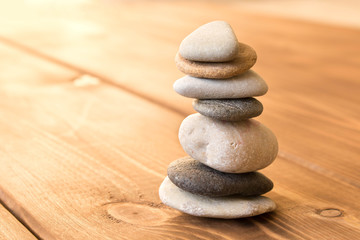Balance the stones on the wooden table.