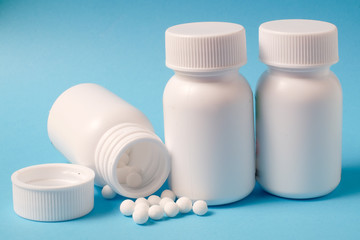 White pills and bottle on blue background
