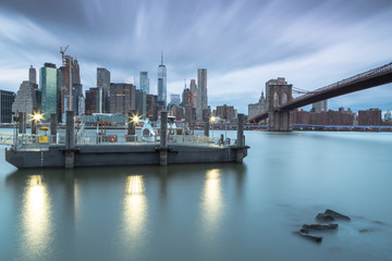 Fototapeta na wymiar View on east river ferry and Downtown manhattan at sunrise with long exposure