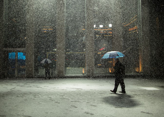 Man walking with umbrella in Manhattan during snow