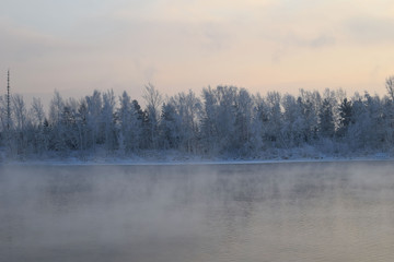 Winter landscape. The ice on the river. The mist over the water. Low air temperature.