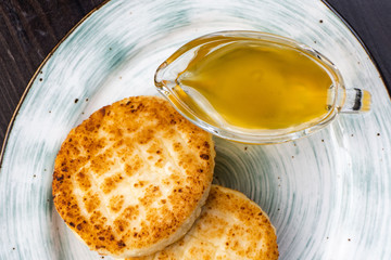 Cheesecakes on the plate with honey and sour cream
