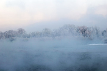 Fototapeta premium Winter landscape. The ice on the river. The mist over the water. Low air temperature.