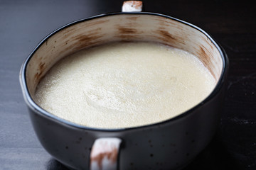 Semolina porridge in a vintage Breakfast bowl on a dark wooden table.