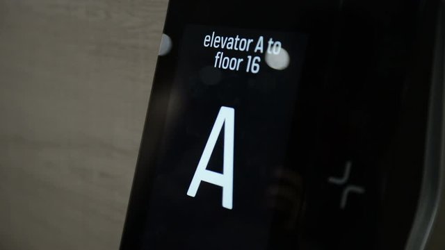 Close-up of male hand pushing touch-screen panel of elevator in business center