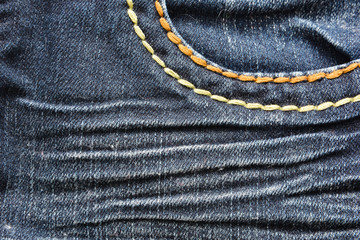Denim fabric texture with yellow stitching