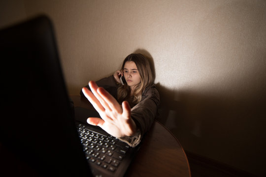 Teen girl excessively sitting at the computer laptop at home. he is a victim of online bullying Stalker social networks.Too much work sleepy stressed young woman sitting