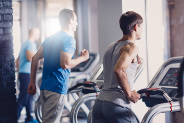 Fototapeta na wymiar A group of young men doing jogging on a treadmill.