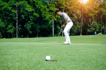 Golfer playing golf in beautiful golf course in the evening golf course with sunshine in thailand