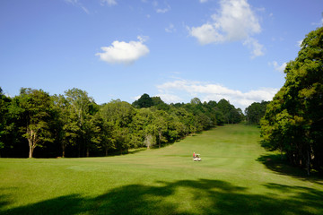 The evening golf course has sunlight shining down at golf course in Thailand