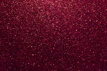 Dark red sparkling background from small sequins, closeup. Brilliant backdrop.