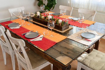 Table ready to eat with a Christmas center, red tablecloth and blue dishes.