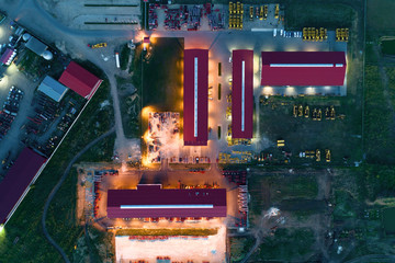 The territory of an industrial plant. Large hangars with a red roof. Aerial view, night shooting © nordroden