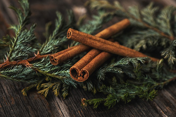 cinnamon sticks on wooden background with pine