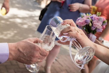 Men's and women's hands holding glasses of champagne