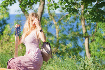 Obraz premium Woman playing acoustic guitar in park