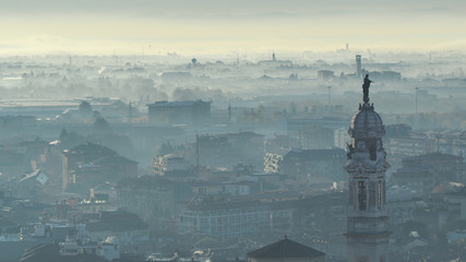 Bergamo, Italy. Amazing landscape of the town covered by the fog arising from the plain in fall season