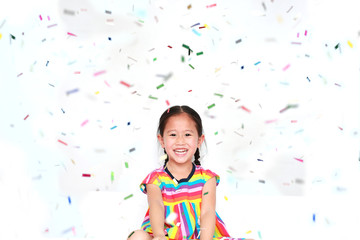 Obraz na płótnie Canvas Happy little child girl with colorful confetti on white background. Happy New Year or Congratulation Concept.