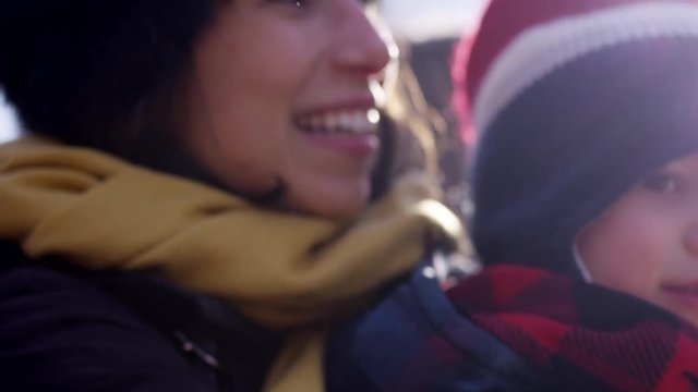 Toddler boy on tractor ride at chirstmas tree farm in winter - bouncing and smiling with mom as they drive into the feild