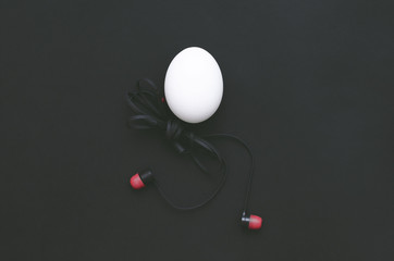 Chicken egg with headphones body is walking on the blue background.
