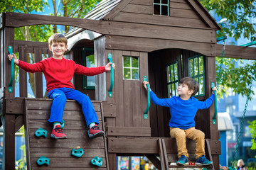 Two little boys playing together and having fun. Lifestyle family moment of siblings on playground....