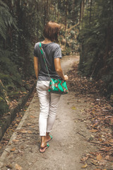 Woman with luxury snakeskin python handbag in the tropical forest. Bali island.