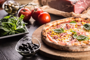 Italian pizza cardinale with ham prosciutto tomatoes corn and basil