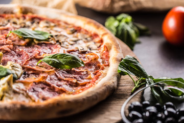 Pizza Quatro Stagioni four seasons traditional italian meal from artichokes mushrooms tomatoes ham prosciutto parmesan cheese and basil