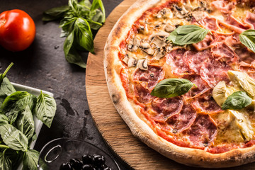 Pizza Quatro Stagioni four seasons traditional italian meal from artichokes mushrooms tomatoes ham prosciutto parmesan cheese and basil