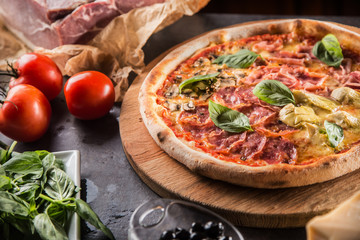 Pizza Quatro Stagioni four seasons traditional italian meal from artichokes mushrooms tomatoes ham prosciutto parmesan cheese and basil