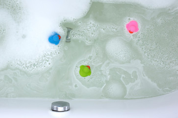Pink, green and blue duck in a bathtub