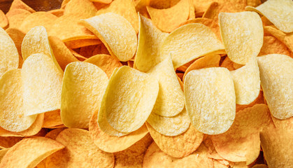 Chips texture crisp potato background of golden unhealthy food .
