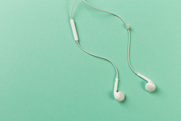White earphones on colour background