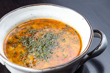 Vegetable soup with red beans, borscht, tomato soup, soup kharcho in a white plate on a black background