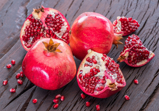 Ripe pomegranate fruits on the wooden background.