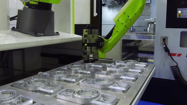 The robot arm sets the parts for machining in the CNC milling center