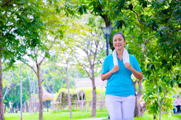 Young Asian woman portrait.She is Jogging in park.She is smile and be happy in good time,Photo concept Health and relax time.