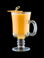 A hot drink with orange, almonds and spices. On dark background. Warming drink.