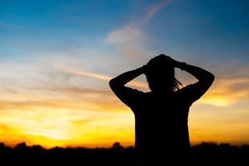 Fototapeta premium Silhouette woman standing sad in the sunset.