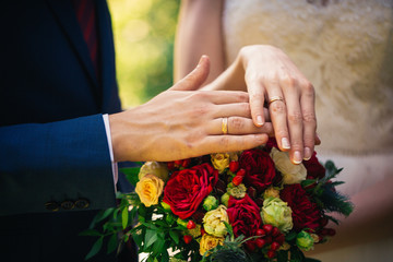 Obraz na płótnie Canvas hands of the bride and groom on a bouquet