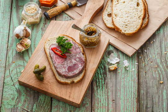 Headcheese sandwich on a cutting board, copy space