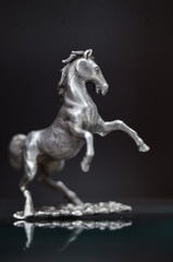 Obraz na płótnie Canvas jewelry, Silver statuette of galloping horses. miniature metal sculpture Stallion reared up. chess piece,