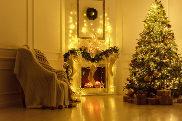 Christmas interior in the living room at evening in lights - fireplace, Christmas tree and chair